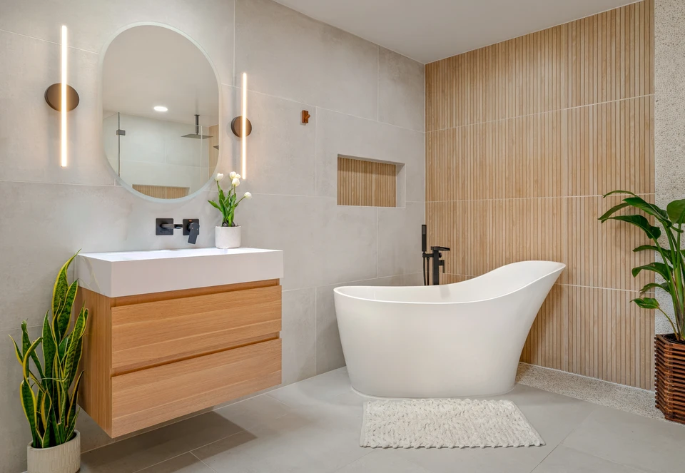 Plombier professionnel intervenant dans une salle de bains moderne pour réparer ou installer une cabine de douche
